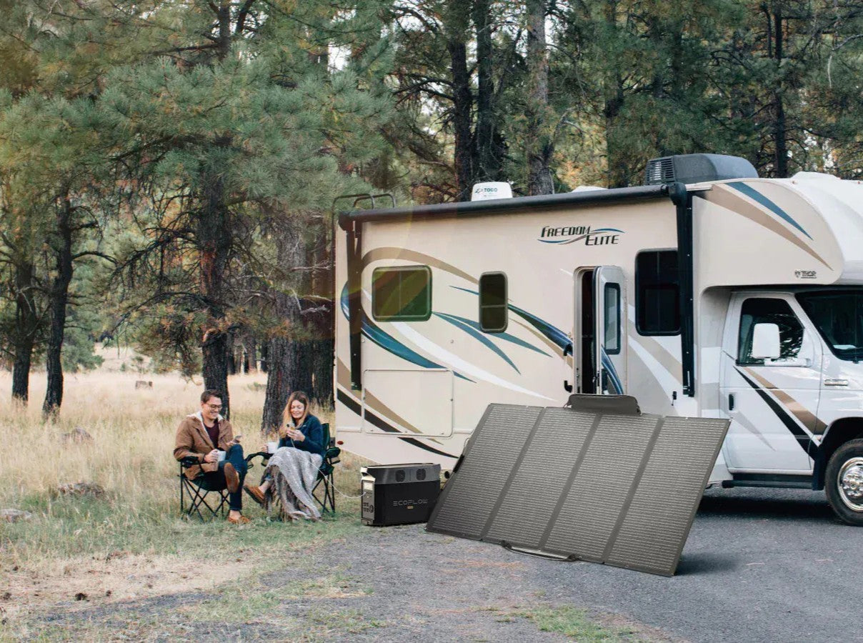 couple charging their best EcoFlow generator with solar panels and using it to power their devices and RV